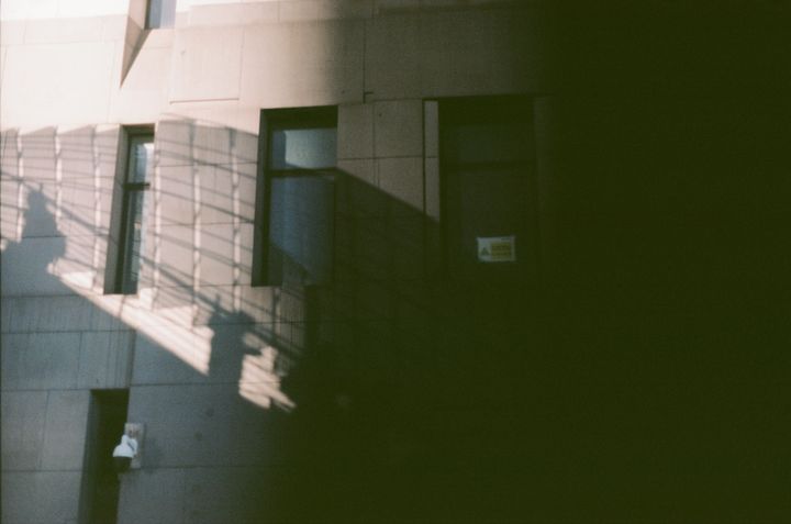 Photo of a wall with the shadow of a staircase, obscured by a large dark area over the image to the right